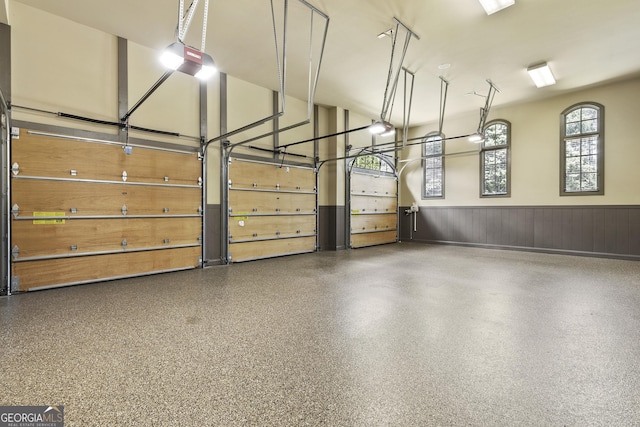 garage with wainscoting and a garage door opener