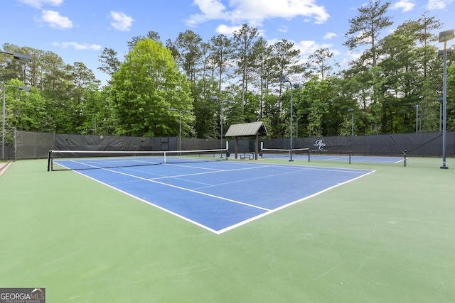 view of tennis court featuring fence and community basketball court