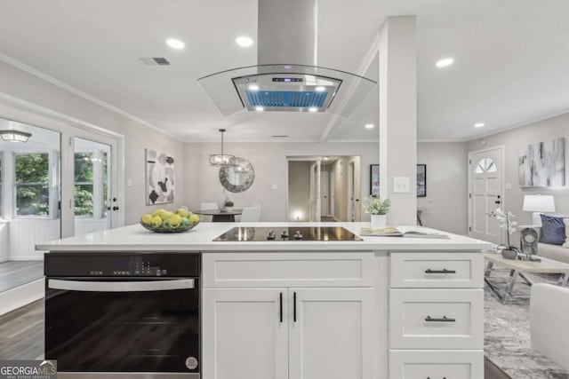 kitchen featuring black electric cooktop, wall oven, open floor plan, white cabinets, and light countertops