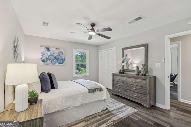bedroom featuring dark wood finished floors, baseboards, a closet, and a ceiling fan