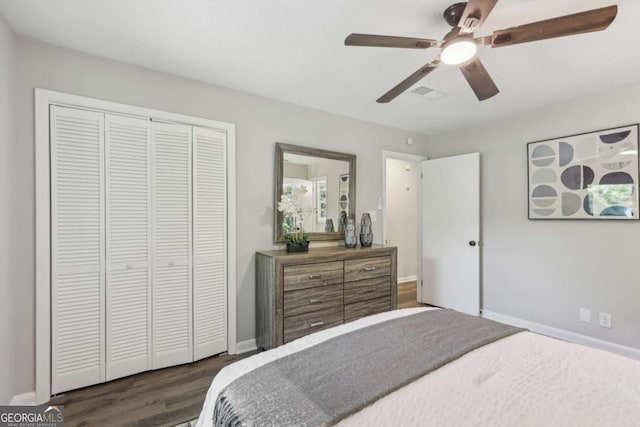 bedroom with dark wood-style flooring, a closet, ceiling fan, and baseboards