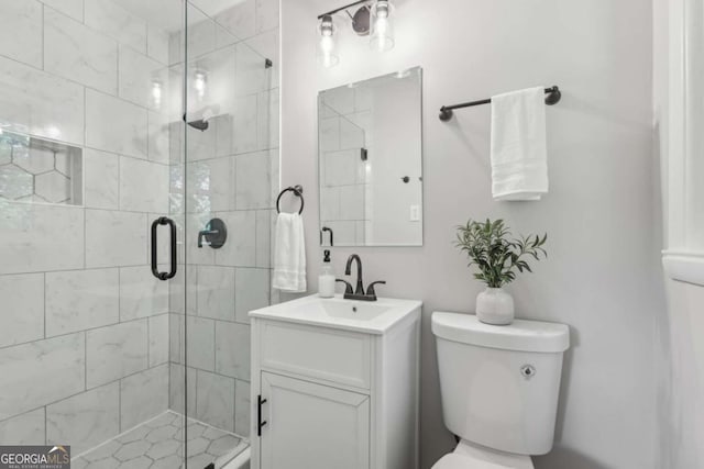 bathroom featuring a stall shower, vanity, and toilet