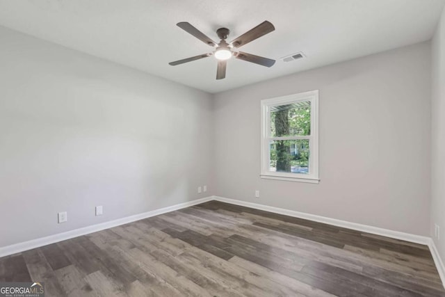 spare room featuring ceiling fan, baseboards, and wood finished floors