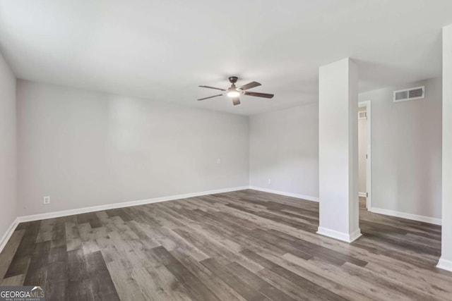 unfurnished room featuring ceiling fan, wood finished floors, and baseboards