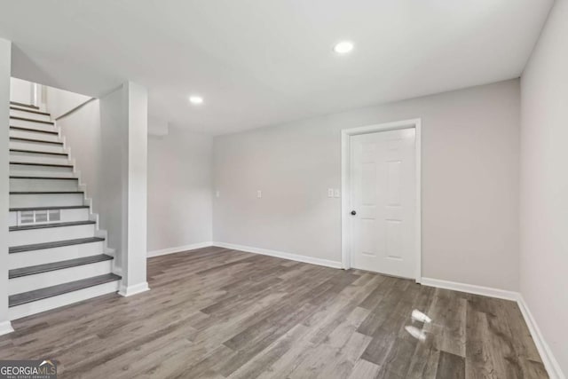basement with wood finished floors, baseboards, stairs, and recessed lighting