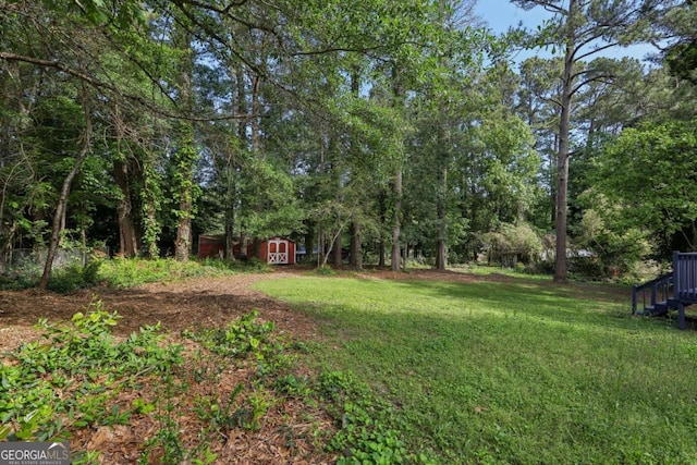 view of grassy yard featuring a storage unit and an outbuilding