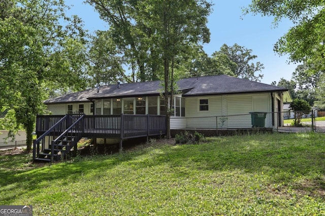 rear view of property featuring a wooden deck, a sunroom, and stairs