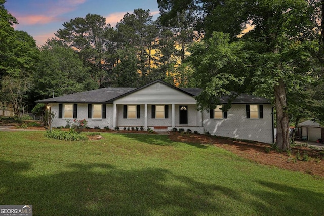 ranch-style home with a front lawn, covered porch, and brick siding