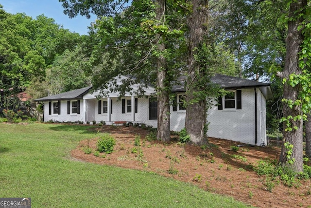 ranch-style home featuring brick siding and a front yard