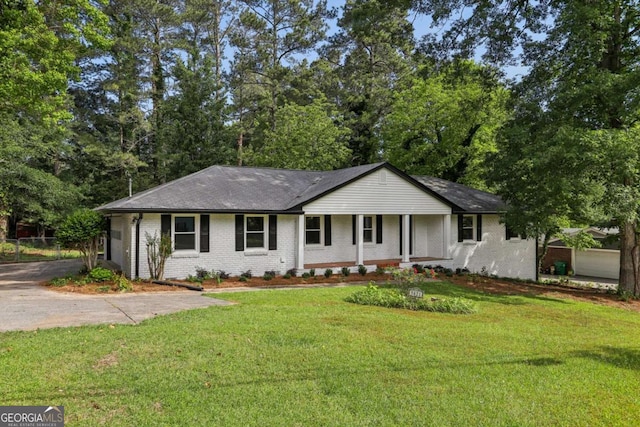 ranch-style house featuring brick siding, a front lawn, covered porch, and a shingled roof