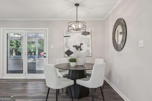 dining room with a chandelier, wood finished floors, baseboards, and crown molding