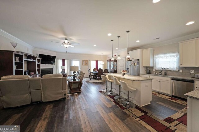2209 Cedar Place Ct, Snellville, GA 30078 - kitchen with appliances with stainless steel finishes, a sink, open floor plan, white cabinets, and a center island