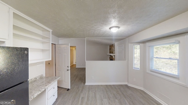 3512 Valley Chase Ct, Lithonia, GA 30038 - unfurnished dining area with a textured ceiling, light wood-type flooring, and baseboards