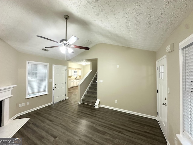 9151 Jefferson Village Dr SW, Covington, GA 30014 - unfurnished living room featuring dark wood finished floors, stairs, a textured ceiling, vaulted ceiling, and ceiling fan