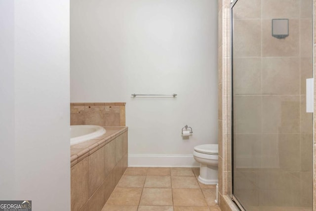 full bathroom with a shower stall, toilet, a garden tub, baseboards, and tile patterned floors