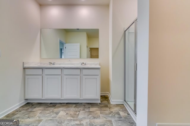 full bathroom featuring a shower stall, double vanity, and baseboards