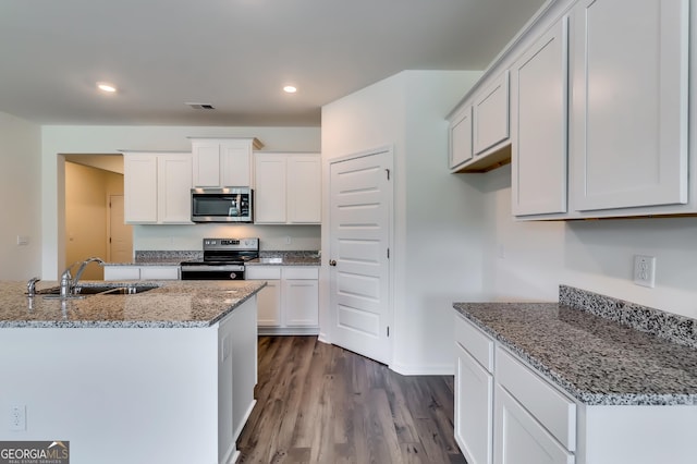 kitchen featuring a sink, stainless steel appliances, light stone countertops, dark wood finished floors, and recessed lighting