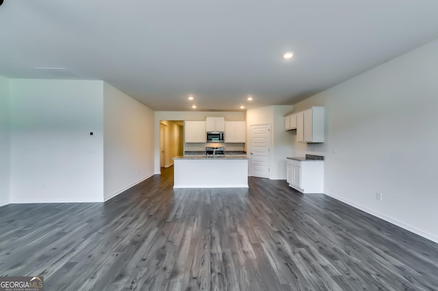 unfurnished living room with dark wood-style flooring, recessed lighting, and baseboards