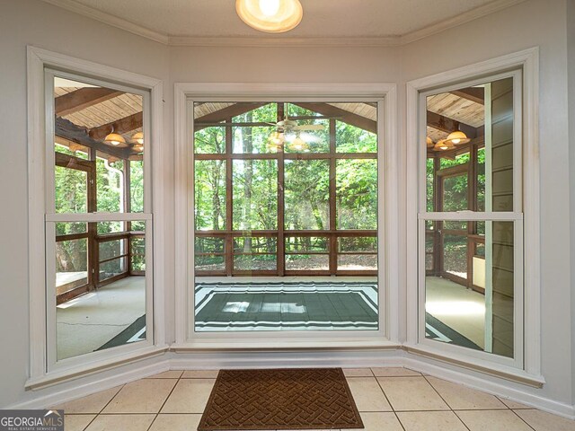 doorway to outside with light tile patterned flooring and ornamental molding