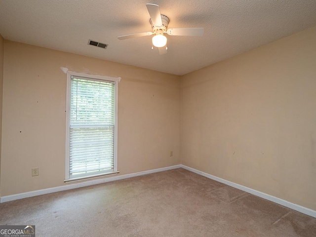 carpeted empty room with ceiling fan, baseboards, and a textured ceiling