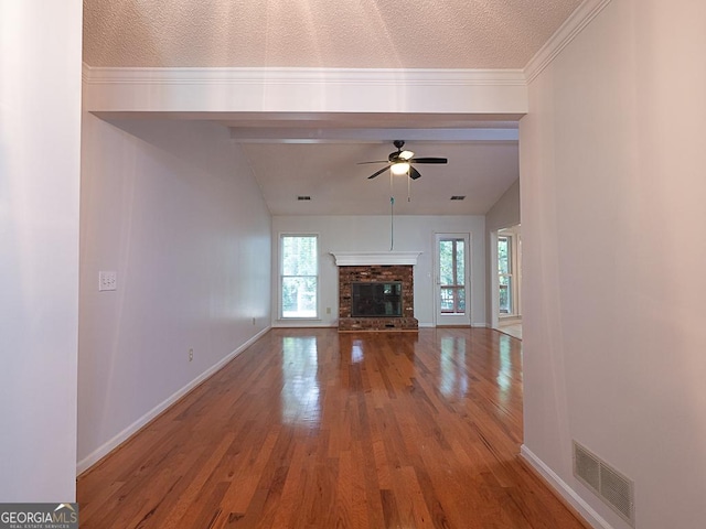 unfurnished living room with wood finished floors, a ceiling fan, baseboards, a brick fireplace, and a textured ceiling