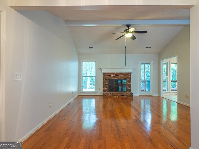 unfurnished living room featuring wood finished floors, ceiling fan, baseboards, and a brick fireplace