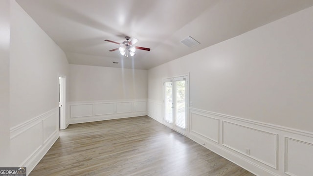 900 Ellesmere Pt, Mcdonough, GA 30253 - empty room with ceiling fan, a decorative wall, light wood-style floors, and wainscoting