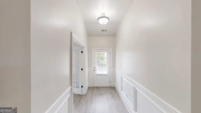 900 Ellesmere Pt, Mcdonough, GA 30253 - doorway to outside with a wainscoted wall, light wood-style flooring, and a decorative wall
