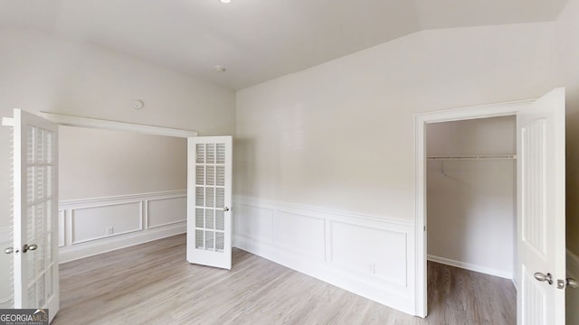 900 Ellesmere Pt, Mcdonough, GA 30253 - unfurnished bedroom featuring a heating unit, wainscoting, wood finished floors, a closet, and lofted ceiling