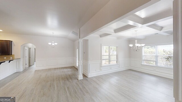 900 Ellesmere Pt, Mcdonough, GA 30253 - empty room featuring a chandelier, beam ceiling, arched walkways, light wood finished floors, and wainscoting