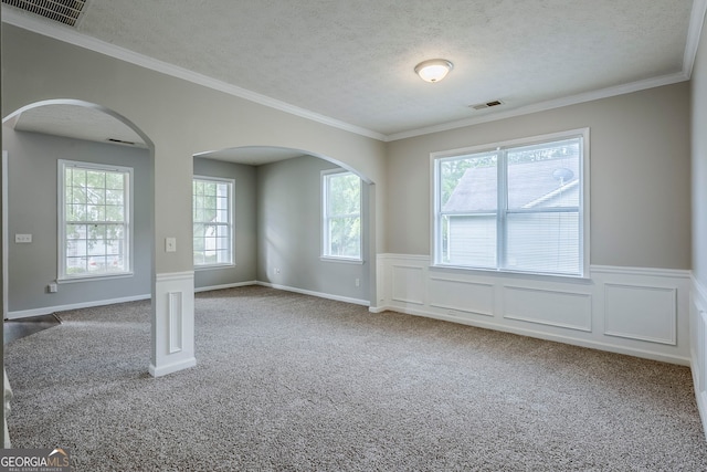 8826 Lakecrest Way, Union City, GA 30291 - empty room featuring a textured ceiling, carpet floors, arched walkways, a wainscoted wall, and ornamental molding