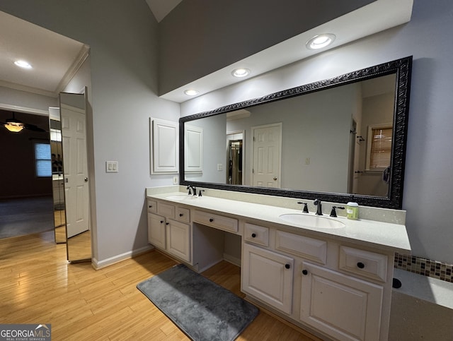 full bath with wood finished floors, double vanity, baseboards, and recessed lighting