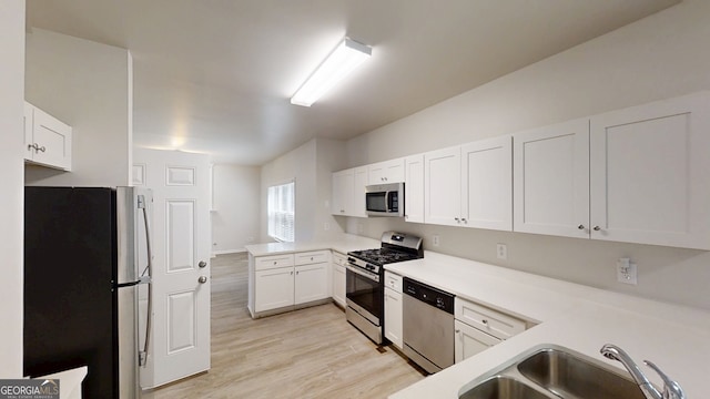 4912 Lightwood Ct NW, Acworth, GA 30102 - kitchen with stainless steel appliances, a sink, a peninsula, light wood-style floors, and light countertops