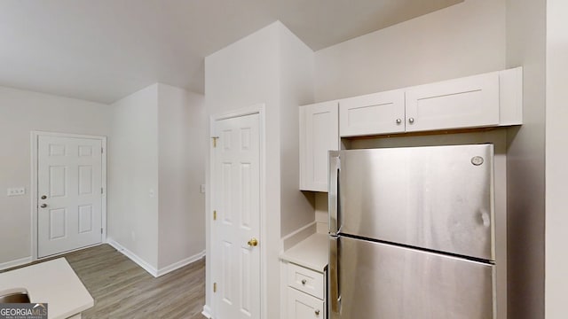 4912 Lightwood Ct NW, Acworth, GA 30102 - kitchen with freestanding refrigerator, light countertops, light wood-style flooring, and white cabinetry
