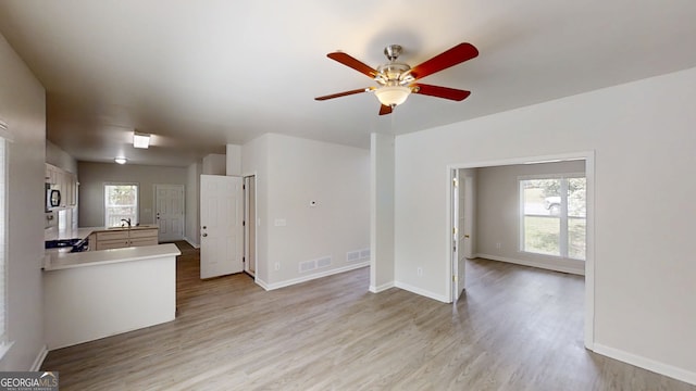 4912 Lightwood Ct NW, Acworth, GA 30102 - unfurnished living room featuring light wood finished floors, a ceiling fan, healthy amount of natural light, and baseboards