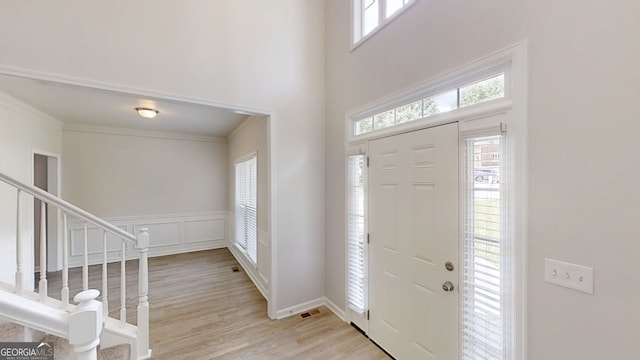 4912 Lightwood Ct NW, Acworth, GA 30102 - entryway with wood finished floors, stairs, crown molding, a towering ceiling, and wainscoting