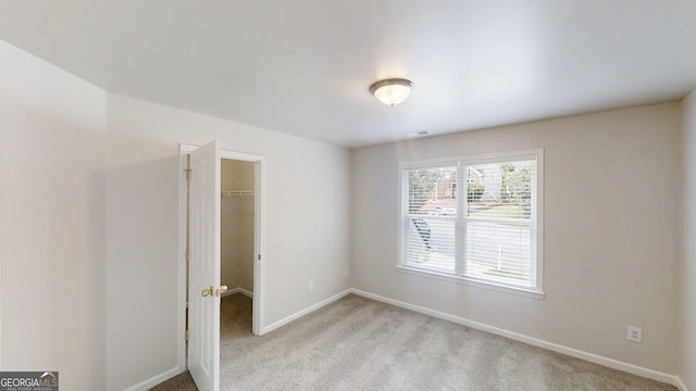 4912 Lightwood Ct NW, Acworth, GA 30102 - unfurnished bedroom featuring a walk in closet, baseboards, light carpet, and a closet