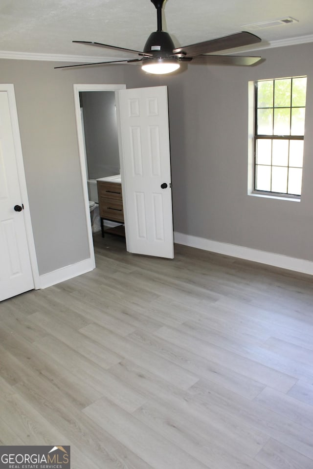unfurnished bedroom featuring crown molding, baseboards, light wood finished floors, and ceiling fan