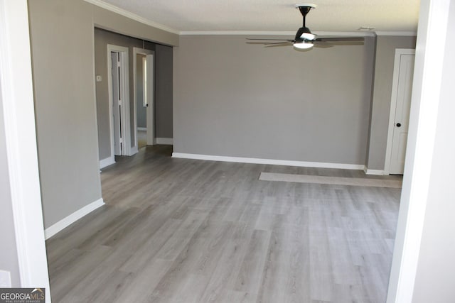unfurnished room featuring crown molding, ceiling fan, wood finished floors, and baseboards