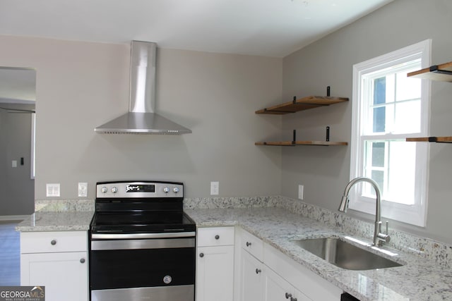 kitchen featuring electric stove, wall chimney range hood, a sink, and plenty of natural light
