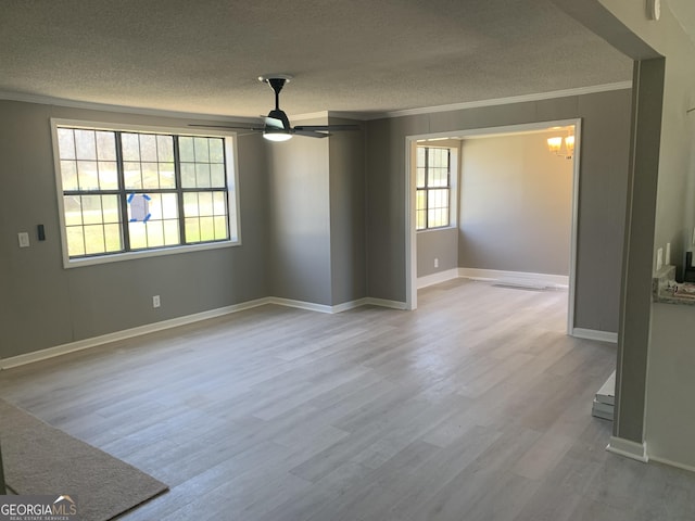 unfurnished room featuring crown molding, a textured ceiling, wood finished floors, a ceiling fan, and baseboards