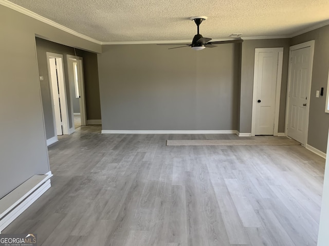 unfurnished living room with crown molding, a textured ceiling, a ceiling fan, wood finished floors, and baseboards