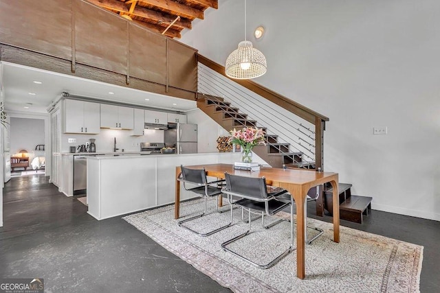 dining area with stairs, a high ceiling, and baseboards