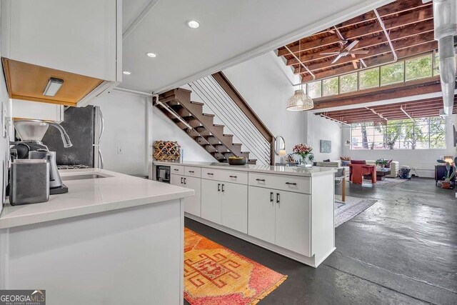 kitchen with white cabinetry, freestanding refrigerator, light countertops, a sink, and recessed lighting
