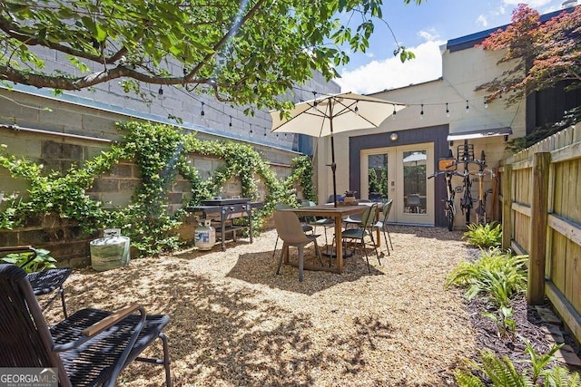 view of patio with a fenced backyard, french doors, and outdoor dining space