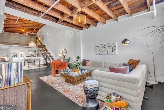 living area featuring wood ceiling, stairway, beam ceiling, and concrete flooring