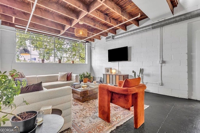 living room featuring wood ceiling and concrete block wall
