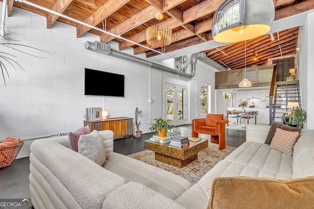 living room with wood ceiling, beam ceiling, finished concrete floors, and concrete block wall