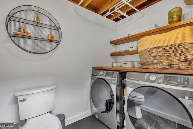 washroom featuring washing machine and clothes dryer and baseboards