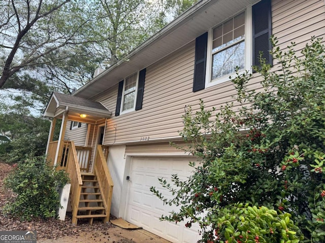 view of home's exterior featuring an attached garage and stairs